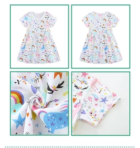 Detail of cartoon unicorn and rainbow print on a white cotton summer dress for girls