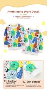 Close-up of colorful cartoon dog prints and ribbed elastic cuffs on boys white sweatshirt