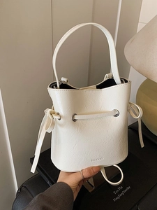 Chic beige bucket bag with drawstring closure and minimalist top handle design