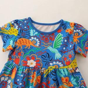 Abito da bambina a maniche corte con stampe di dinosauri e fiori colorati su blu