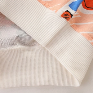Kids sweatshirt detail featuring white ribbed cuffs and colorful abstract geometric patterns