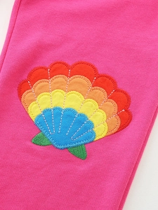 Girls' rose pink knit pants featuring a colorful shell patch embroidery detail