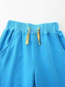 Kids blue casual joggers featuring a ribbed elastic waist and bright yellow drawstrings