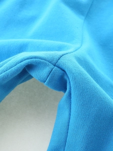 Close-up of royal blue knitted cotton trousers showing durable reinforced stitching details
