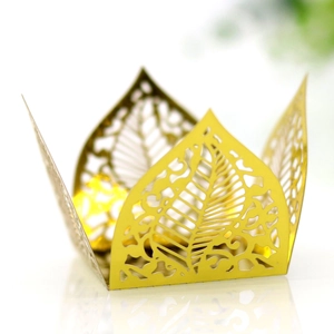 Macro shot of gold hollow leaf laser cut candy box with elegant metallic paper texture