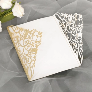 Détail d'invitation de mariage découpée au laser avec paillettes dorées et motifs ajourés