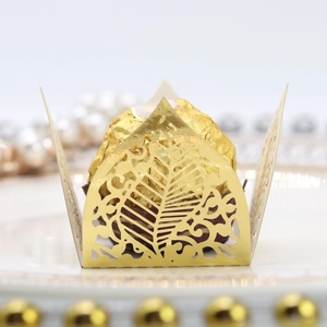 Macro detail of laser-cut gold leaf pattern wrapper for chocolate wedding favors
