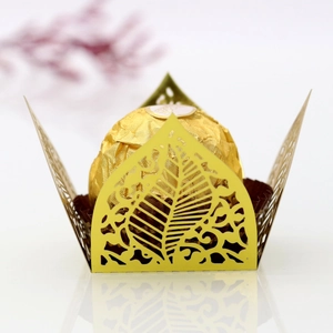 Macro detail of laser-cut gold leaf pattern chocolate wrapper for wedding party decor