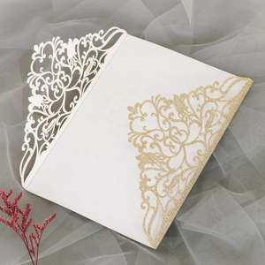 Détails d'invitation de mariage découpée au laser avec paillettes dorées et motifs ajourés