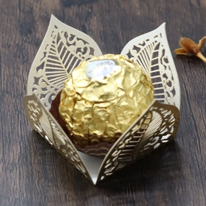 Intricate laser-cut hollow leaf chocolate wrapper in beige pearlescent paper