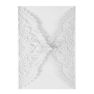 Detail of laser-cut wedding invitation cover with intricate white lace floral patterns