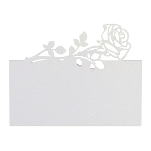 Macro view of white laser-cut rose place card with pearlescent texture for weddings