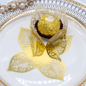 Detail of laser-cut hollow leaf chocolate holders with metallic pearlescent paper texture