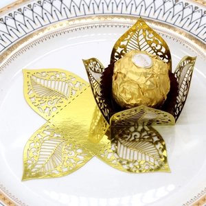 Macro view of golden hollow leaf chocolate wrappers for wedding favors and party decor