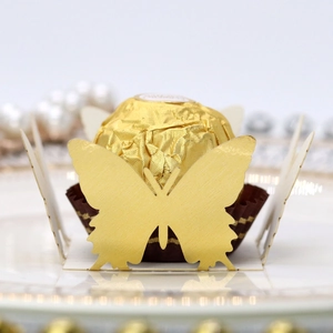 Macro shot of laser-cut gold butterfly paper holder for party chocolate decor