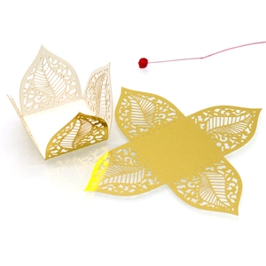 Macro detail of laser-cut hollow leaf patterns on champagne gold pearlescent candy box
