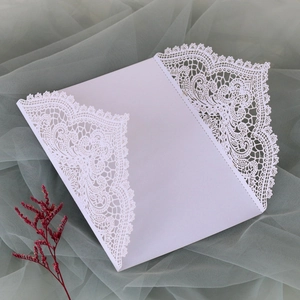 Detailansicht des filigranen Laserschnitt-Spitzendesigns der weißen Hochzeitseinladung