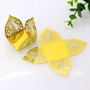 Macro detail of laser-cut hollow leaf chocolate candy box in shiny metallic gold paper