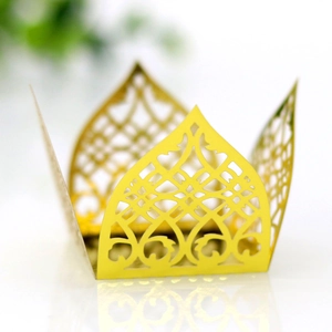 Macro shot of laser-cut gold wedding candy box with intricate floral patterns