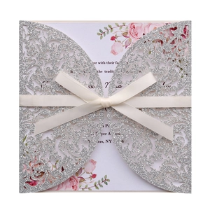 Détail de l'invitation de mariage découpée au laser avec paillettes et ruban