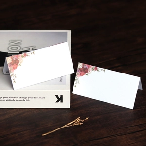 Elegant white floral place cards for weddings with printed pink roses and V-fold design
