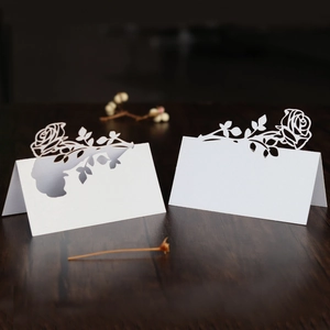 Detailed laser-cut white pearl paper rose place cards for wedding or banquet table