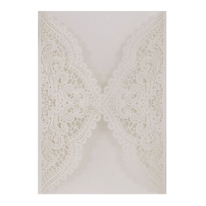 Detailed laser-cut lace pattern on white wedding invitation sleeve with floral scrollwork