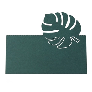 Détail d'un marque-place vert foncé avec un motif de feuille de Monstera découpée