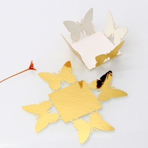 Flat lay of laser-cut gold pearlescent butterfly decorative box for wedding party favors