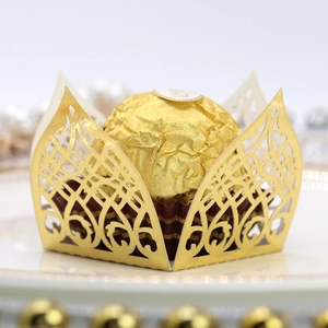 Close-up of golden laser-cut chocolate wrappers with intricate floral vine patterns