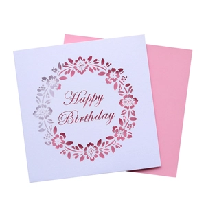 Close-up of laser-cut floral wreath and Happy Birthday text on paper greeting card