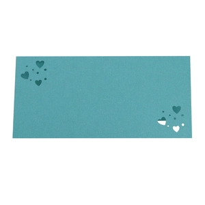 Detalle de tarjeta de boda verde azulado con elegantes patrones de corazón cortados con láser