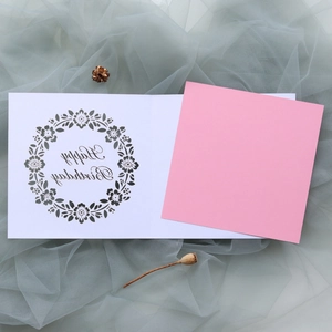 Detailed view of laser-cut floral birthday card with pink insert on blue tulle