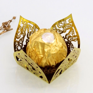 Macro shot of a laser-cut gold butterfly cupcake liner with Ferrero Rocher inside
