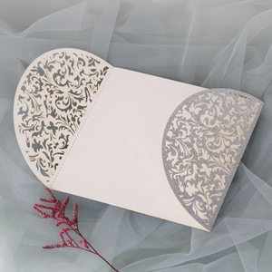 Détail d'un faire-part de mariage découpé au laser avec paillettes argentées et dentelle