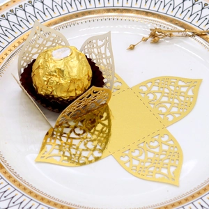 Macro shot of gold laser-cut hollow candy box with pearl paper and floral lace texture