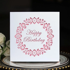 Detail of laser-cut floral wreath and pink Happy Birthday text on white paper card