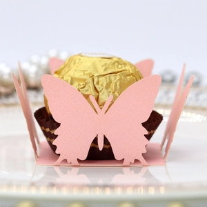 Macro shot of laser-cut pink butterfly chocolate box with pearl paper texture for weddings