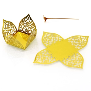 Flat and folded laser-cut gold wedding favor boxes with intricate hollow patterns
