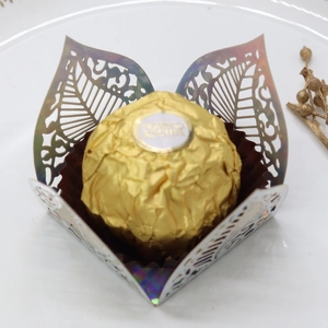 Macro detail of laser cut leaf candy box with iridescent finish and chocolate inside
