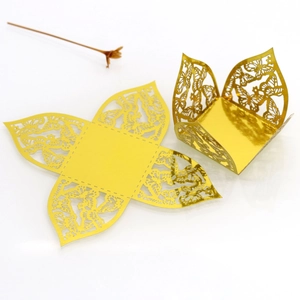 Detail of gold laser-cut butterfly candy box with reflective mirror finish for weddings
