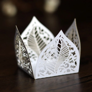Detail showing laser-cut white pearlescent paper hollow leaves for gift candy boxes
