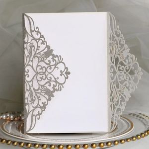 Détail de l'invitation découpée au laser blanche avec paillettes argentées et perles