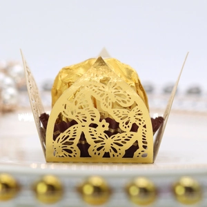 Makro-Detail von lasergeschnittenen Gold-Schmetterling-Cupcake-Hüllen für Hochzeiten