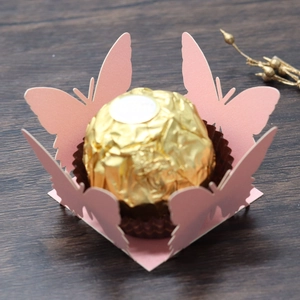 Macro detail of laser-cut pink butterfly candy box with hollow lace design for weddings