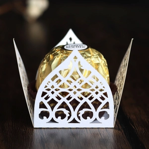 Macro detail of white laser-cut pearlescent paper candy wrapper with elegant lace patterns