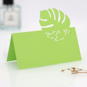 Détail de marque-places verts découpés au laser avec motif de feuille de monstera
