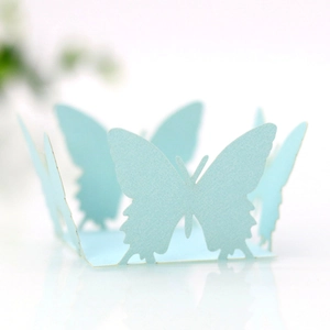 Close-up of light blue laser-cut butterfly cupcake wrapper with pearl paper texture