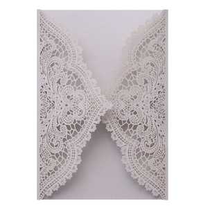 Detailed laser-cut wedding invitation cover with intricate pearlescent white lace pattern