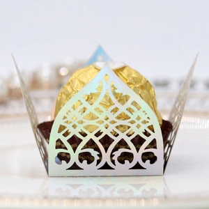 Macro detail of laser-cut pearl paper candy box with intricate European vine patterns
